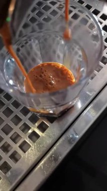 Kahve makinesi taze demlenmiş espresso dolduruyor.