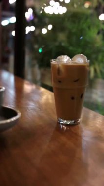 Buzlu kahvenin yanındaki masaya çay tabağı ile boş fincan koy.