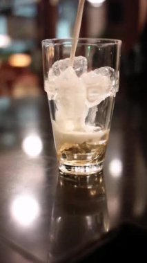 Bokeh arkaplanlı bir bardak süte espresso döküyorum.