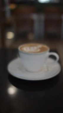 Masada köpüklü bir fincan kahve.