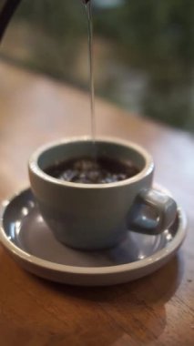 Kahve yapmak için bardağa sıcak su döküyorum.