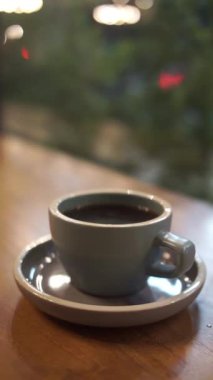 Bir fincan sıcak kahve ya da ahşap masada çay.