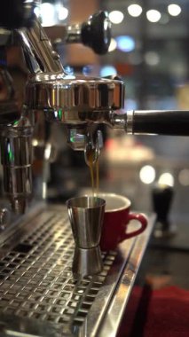 Kahve makinesinden taze espresso akıyor.