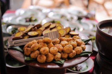 Perkedel, Endonezya usulü kızarmış lezzetler, ahşap bir tabakta sergilenir. Patates püresi ve kıyma, küçük yuvarlak parçalar şeklinde ve altın kahverengiye kızartılmış.