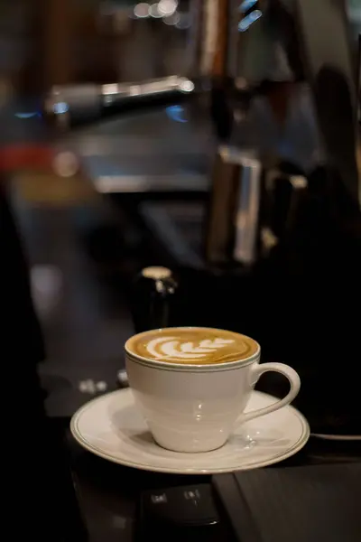 Masada köpüklü bir fincan sıcak latte.