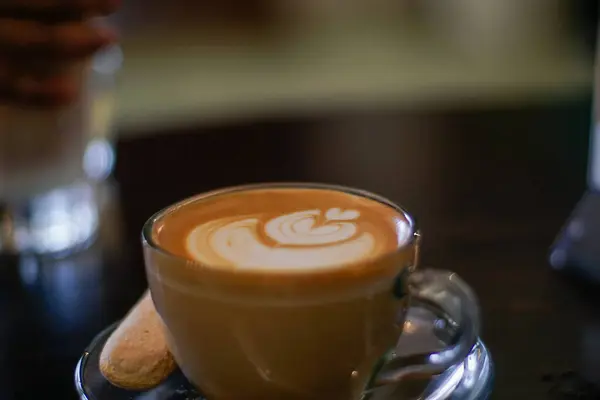 Tezgahta köpüklü bir fincan sıcak latte.