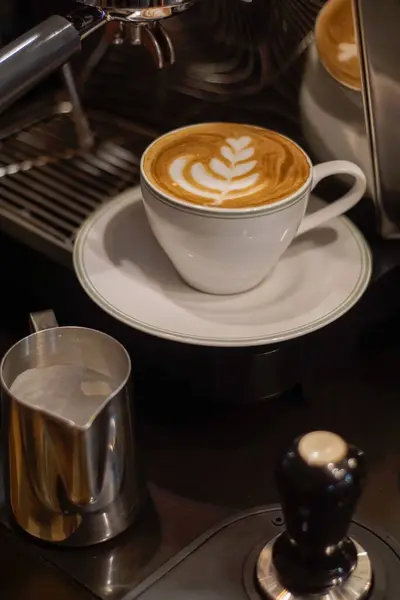 Tezgahta köpüklü bir fincan sıcak latte.