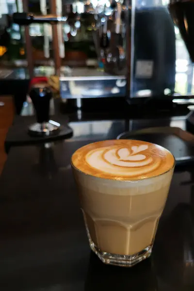 Tezgahta köpüklü bir bardak kahve.