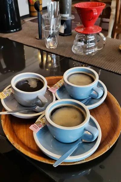 Kafe tezgahında üç fincan kahve.