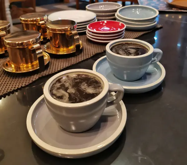 Kafe tezgahında iki fincan kahve.