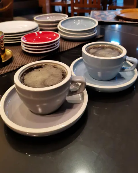 Kafe tezgahında iki fincan kahve.
