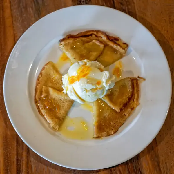 Krep Suzette veya portakal soslu krep ve vanilyalı dondurma. Çeyrekliklere katlanmış ince krepler beyaz bir tabakta bir kepçe vanilyalı dondurmanın etrafına dizilir. Krepler parlak bir portakal sosuyla serpilmiş..