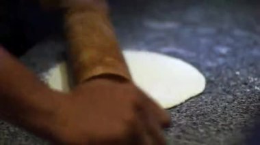 Hamuru mermer yüzeyde tahta bir oklavayla düzleştir.