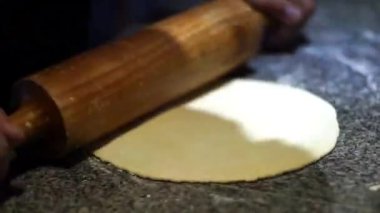 Hamuru mermer yüzeyde tahta bir oklavayla düzleştir.