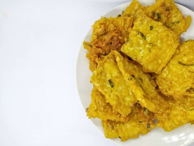 Tempe Mendoan, beyaz arka planda izole edilmiş, dilimlenmiş pırasa ve baharat karışımıyla un hamuru ile kaplanmış geleneksel Endonezya kızarmış gıdası.