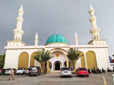 Teluk Jambe, Karawang 'daki caminin önünden inanılmaz bir manzara. Arka planda karanlık bir gökyüzü var.