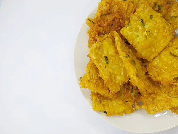 stock image Tempe Mendoan is Indonesian traditional fried food made from tempeh covered in flour batter with a mixture of sliced leeks and spices, isolated on white background