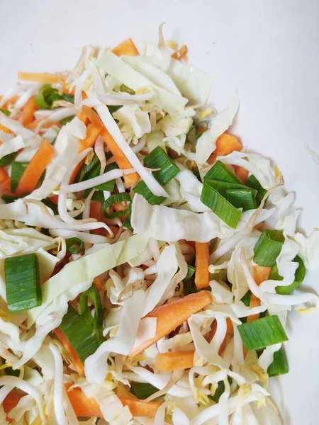 Cut vegetables there are carrots, cabbage, bean sprouts and scallions. To make flour fried vegetables in Indonesia called bakwan sayur