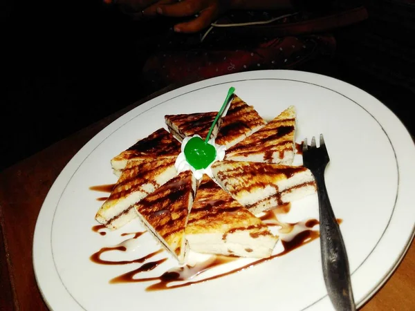 上有巧克力酱和绿色樱桃的烤面包盘 — 图库照片