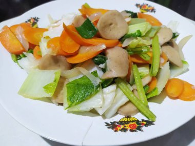 Soğan ve sarımsakla pişirilmiş havuç, lahana, hardal yeşili ve köfte dilimleri. Basit sebze kızartması.