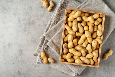 Küçük tahta bir kutunun içindeki kabuktaki fıstıklar. Hafif bir arkaplan, yakın çekim üst görünümü