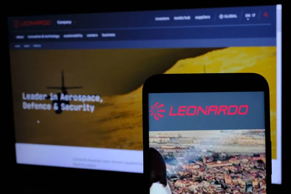 stock image The Leonardo spa company logo seen through a smartphone and in the background the website of the company listed on the Milan Stock Exchange in the Ftse MIB index.