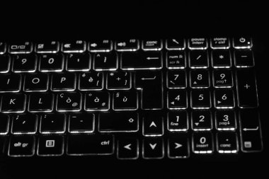 ASUS oyun dizüstü bilgisayarının arka planındaki klavyenin sağ tarafında, siyah-beyaz çekilmiş..