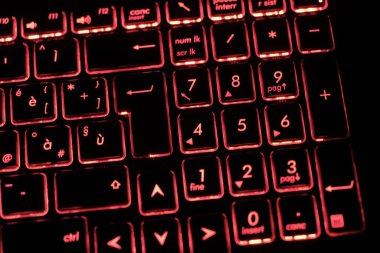 Sayısal tuş takımının ayrıntıları ve bir dizüstü bilgisayarın arka ışıklandırmalı klavyesinin (kırmızı LED) giriş anahtarı. Hafifçe sola doğru yan etki.