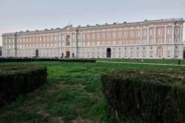 The facade of the Royal Palace of Caserta portrayed from the front garden in Piazza Carlo di Borbone. Photo taken during the blue hour.