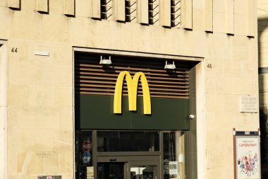 Napoli 'deki Piazza Municipio' nun tarihi karargahında bir restoran zinciri olan McDonald 's logosu. McDonald 's, New York Menkul Kıymetler Borsası' nda yer alan bir fast food zinciri.).