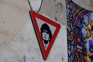 Road signs with the face of Diego Armando Maradona. The artistic work is located in Largo Maradona in Naples. clipart