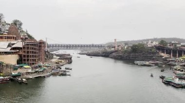 Omkareshwar Tapınağı 'ndaki sakin tekne yolculuğunun ariel görüntüsünü deneyin. Nehir manzarasının, etrafındaki tepelerin ve görkemli tapınağın tadını çıkarabilirsiniz. Maneviyat ve doğal güzelliğin mükemmel bir karışımı.!