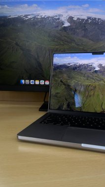 Monitör ve dizüstü bilgisayarı olan modern ofis düzeni, üretkenlik ve çoklu görev için mükemmel.