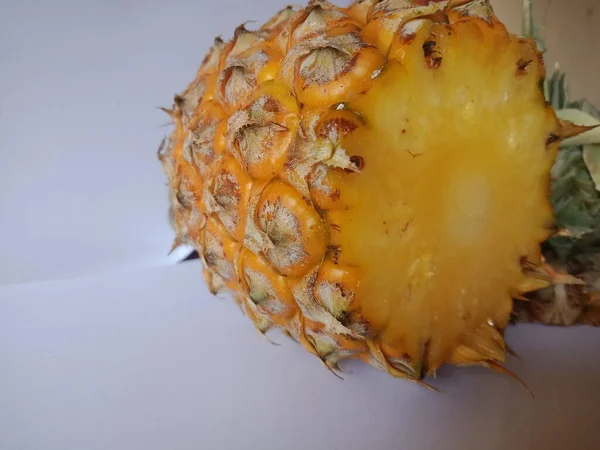 Hand holding Ananas comosus or yellow pineapple. Look delicious. white isolated background.
