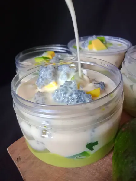 Lezzetli avokado sütlü peynir. Kalın süt sosundan, krem peynirden, avokado püresi, avokado dilimleri ve fesleğen tohumlarıyla kaplı.