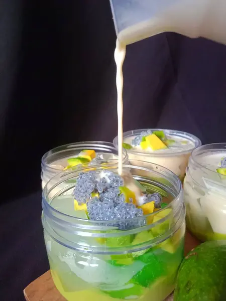 Lezzetli avokado sütlü peynir. Kalın süt sosundan, krem peynirden, avokado püresi, avokado dilimleri ve fesleğen tohumlarıyla kaplı.