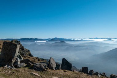 Bask bölgesindeki La Rhune dağının panoramik manzarası. Arka planda dağlar ve biraz sis var. 