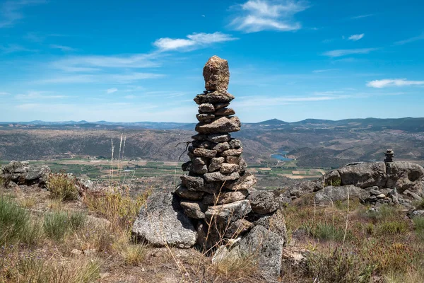 stock image Pyramid of stones on some rocks next to the cork oak swing in Castedo, Torre de Moncorvo, Portugal