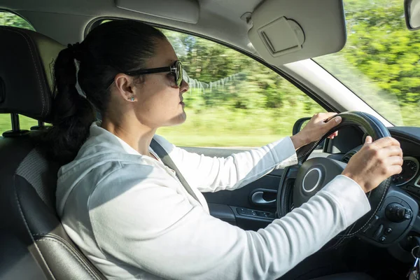 Concentrated female driver driving her vehicle