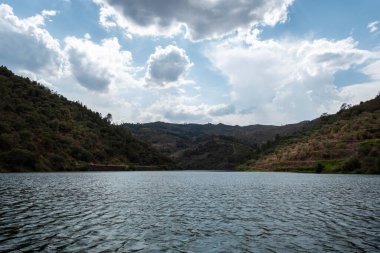 Tepeler ve dağların arasında bulutlu bir günde Portekiz 'de St. Lawrence yakınlarındaki Tua Nehri.