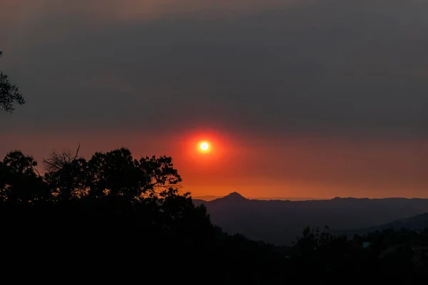 Sunset on the horizon with the sky with smoke from the fires and with Senhora da Cunha hill in the background