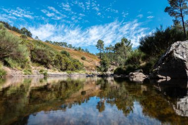 Portekiz 'in Serra do Alvao kentindeki Fisgas de Ermelo dağından akan su akıntısı, gökyüzünde bulutlar olan bir günde...