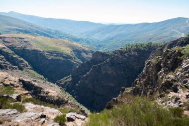 Serra do Alvao 'daki Fisgas de Ermelo' nun panoramik manzarası, önünde büyük ve yüksek uçurumlar ve arkasında büyük dağlar