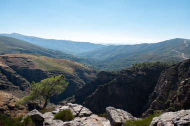 Serra do Alvao 'daki Fisgas de Ermelo' nun panoramik manzarası, önünde büyük ve yüksek uçurumlar ve arkasında büyük dağlar