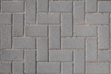 Kaldırımı oluşturan gri kaldırım taşı dokusu yan yana dizilmiş.