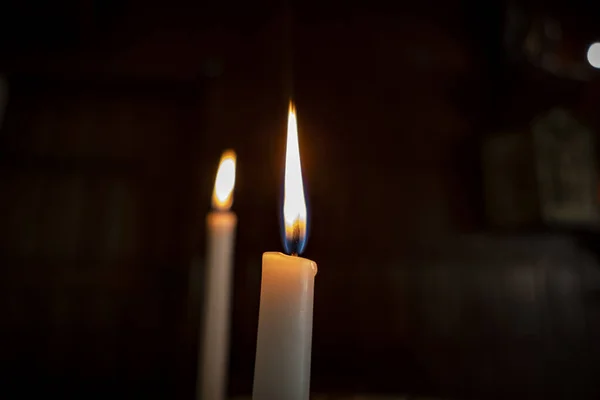 在教堂内部的黑色背景下点燃蜡烛 — 图库照片