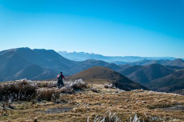 Genç turist, soğuk bir sabahta Bask Bölgesi 'ndeki Artzamendi dağında büyük bir buzla fotoğraf çekiyor.