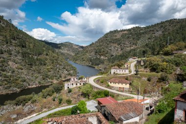 Tepeler ve dağların arasında Tua Nehri ve Portekiz 'in Tras Montes kentindeki Sao Lourenco kaplıca köyünün bir kısmı bulutlu bir günde