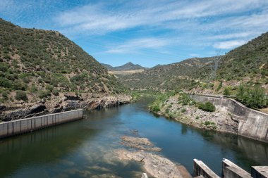 Portekiz 'in Tras os Montes kentindeki Valeira hidroelektrik barajının yanındaki Douro nehri, tepeler ve dağlar arasında.