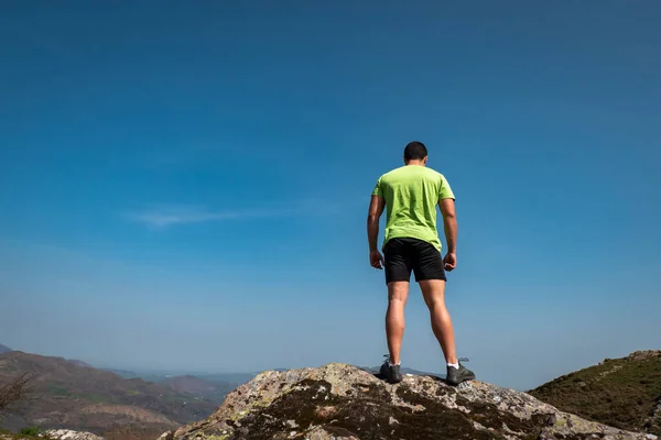 stock image Young tourist on top of the mountain enjoying the scenery around him while resting